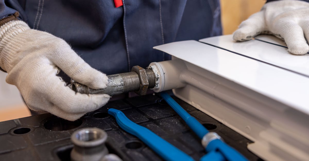 Close-up of a plumber installing a radiator pipe using specialized tools