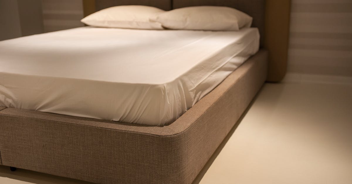 Bedroom with white sheets showing common areas to inspect for bed bugs