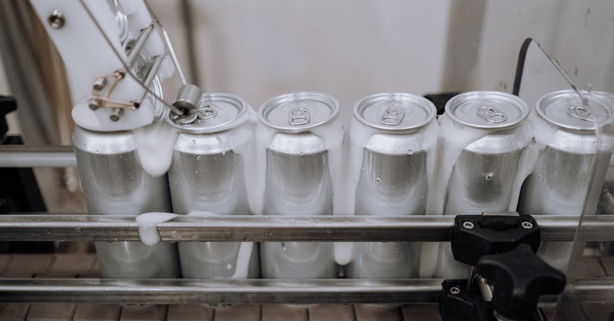 Close-up of aluminum cans on an assembly line in a modern brewery showing automation and machinery at work.