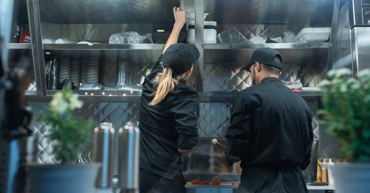 Two chefs working together in a commercial kitchen, preparing food.