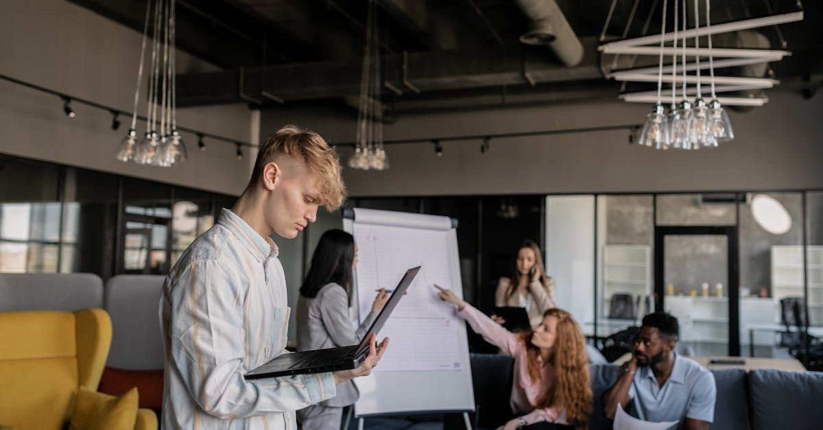 Young professionals collaborating in a modern office space with flip charts and laptops.
